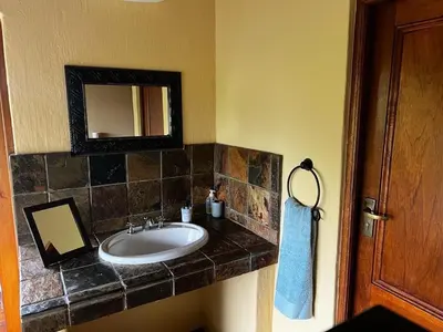 a bathroom with a sink and a mirror at Mokaikai - Elephants Crossing - Moi Exclusive Luxury Villa in Mabula