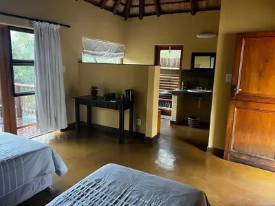 a bedroom with a bed and a desk in a room at Mokaikai - Elephants Crossing - Moi Exclusive Luxury Villa in Mabula