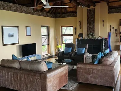 a living room with two couches and a tv at Mokaikai - Elephants Crossing - Moi Exclusive Luxury Villa in Mabula