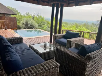 a patio with wicker furniture and a swimming pool at Mokaikai - Elephants Crossing - Moi Exclusive Luxury Villa in Mabula