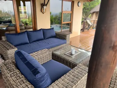 a patio with a blue couch and a table at Mokaikai - Elephants Crossing - Moi Exclusive Luxury Villa in Mabula