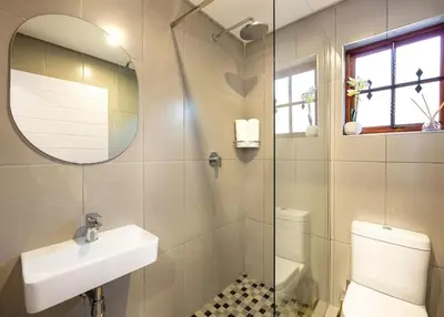 a bathroom with a toilet and a sink and a mirror at ILanga Air B&B in Nelspruit
