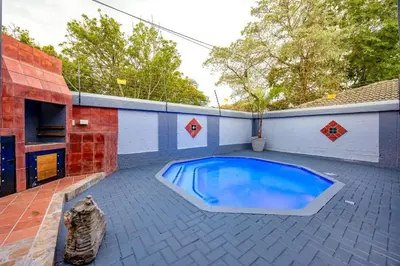 a small swimming pool on a patio with a house at ILanga Air B&B in Nelspruit