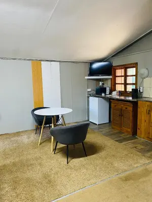 a kitchen with a table and chairs in a room at Tranquilo Guesthouse in Ermelo