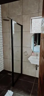 a bathroom with a shower and a sink at Lazél Apartments in Ermelo