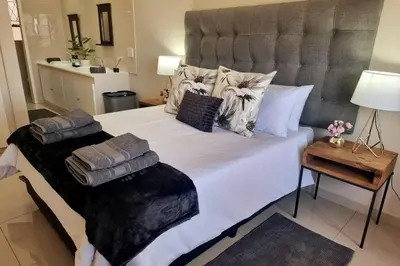 a bedroom with a large white bed with pillows on it at Waters View Villa, 5 Bedroom House in Hartbeespoort