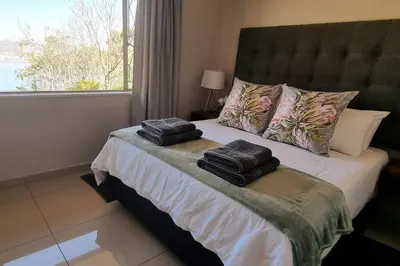 a bedroom with a bed with two towels on it at Waters View Villa, 5 Bedroom House in Hartbeespoort