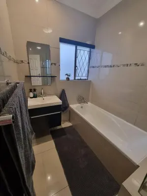 a bathroom with a bath tub and a sink at Waters View Villa, 5 Bedroom House in Hartbeespoort