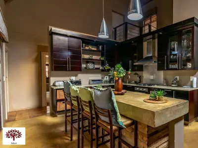 a kitchen with a large wooden table with chairs at Zebula Golf and Wildlife Estate - Africa Breathing Pax 8 - Moi Signature Exclusive Villa in Mabula