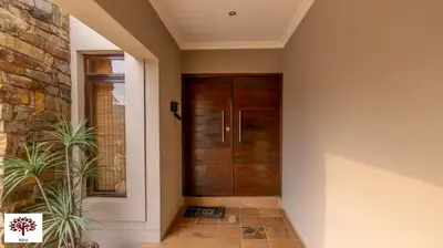 a hallway with a wooden door and a plant at Zebula Golf and Wildlife Estate - Africa Breathing Pax 8 - Moi Signature Exclusive Villa in Mabula