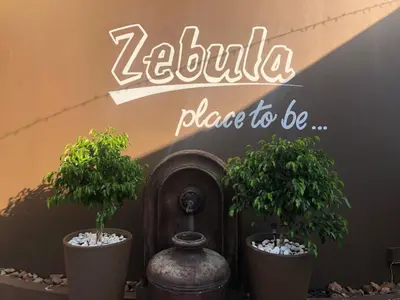 two potted trees in pots in front of a sign at Zebula Golf and Wildlife Estate - Africa Breathing Pax 8 - Moi Signature Exclusive Villa in Mabula