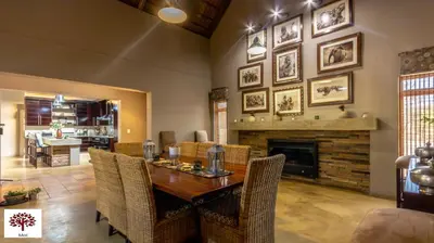 a dining room with a table and chairs and a fireplace at Zebula Golf and Wildlife Estate - Africa Breathing Pax 8 - Moi Signature Exclusive Villa in Mabula