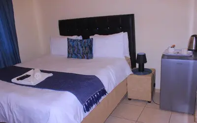 a bedroom with a large bed and a television at Vutomi Guesthouse in Burgersfort