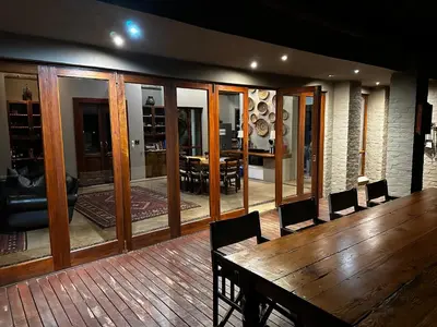 a dining room with a wooden table and chairs at Mokaikai - Leopards Leap - Moi Exclusive Luxury Villa in Mabula