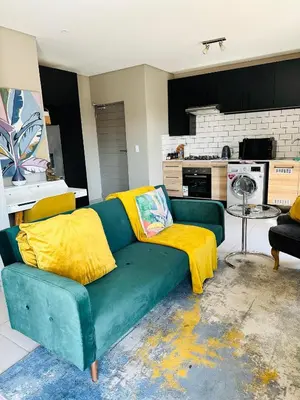 a green couch with yellow cushions in a living room at Centurion Marnard Luxury Apt in Centurion