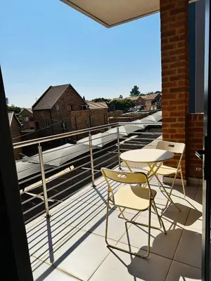 a balcony with two chairs and a table on a roof at Centurion Marnard Luxury Apt in Centurion