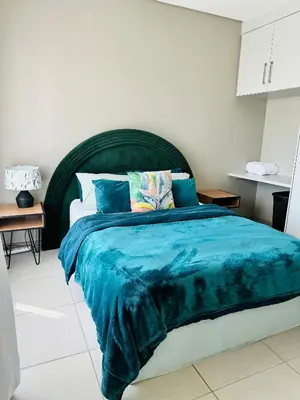 a bedroom with a large bed with a blue blanket at Centurion Marnard Luxury Apt in Centurion