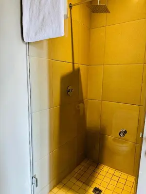 a bathroom with a shower with a yellow tile floor at Centurion Marnard Luxury Apt in Centurion