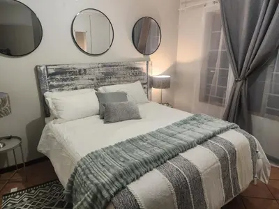 a bedroom with a bed with mirrors on the wall at Beagle Sands in Pretoria