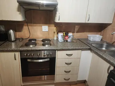 a small kitchen with a stove and a sink at Beagle Sands in Pretoria