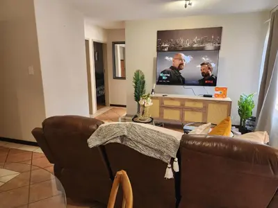 a living room with a couch and a flat screen tv at Beagle Sands in Pretoria