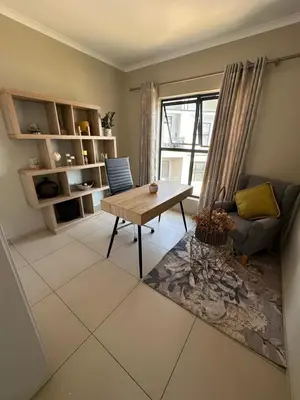 a living room with a table and a couch at Tranquility in Carlswald in Midrand
