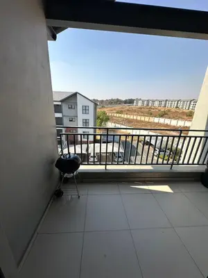 a balcony with a chair and a view of a building at Tranquility in Carlswald in Midrand