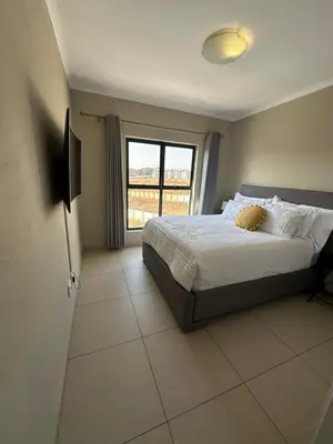 a bedroom with a bed and a large window at Tranquility in Carlswald in Midrand