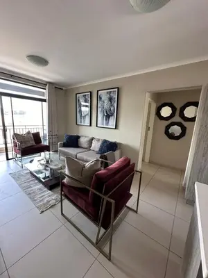 a living room with a couch and a table at Tranquility in Carlswald in Midrand