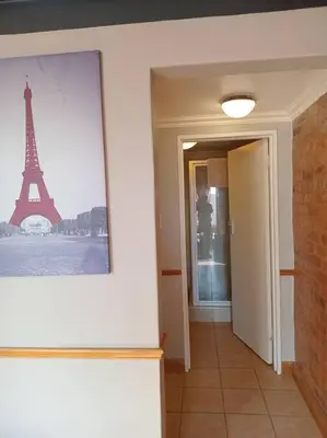 a hallway with a picture of the eiffel tower at Calswald's Skyline Sanctuary in Midrand