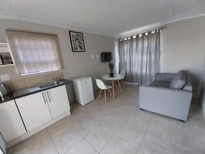 a kitchen and living room with a couch and a table at khutsong Apartments in Secunda