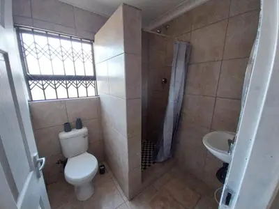 a bathroom with a toilet and a shower and a sink at khutsong Apartments in Secunda