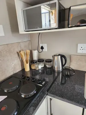 a kitchen with a stove and a counter top at khutsong Apartments in Secunda