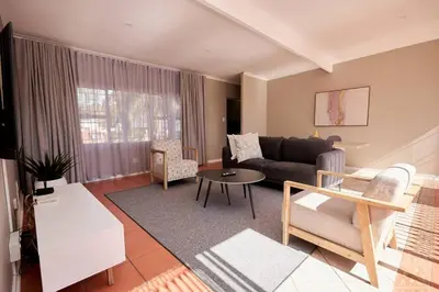 a living room with a couch and a table at Cozy Apartment close to Menlyn in Pretoria