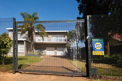 a gate in front of a building with a sign on it at Cozy Apartment close to Menlyn in Pretoria