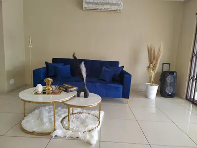 a living room with a blue couch and a table at Palma spaces in Pretoria