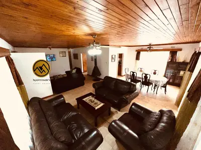 a living room with leather furniture and a dining room at Mantombi's Guest House in Graskop