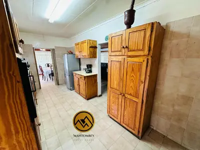 a kitchen with wooden cabinets and a refrigerator at Mantombi's Guest House in Graskop