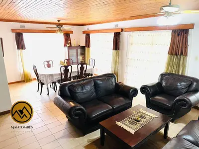 a living room with leather furniture and a table at Mantombi's Guest House in Graskop