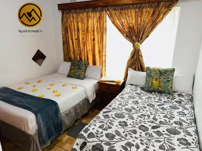 a bedroom with two beds and a window at Mantombi's Guest House in Graskop