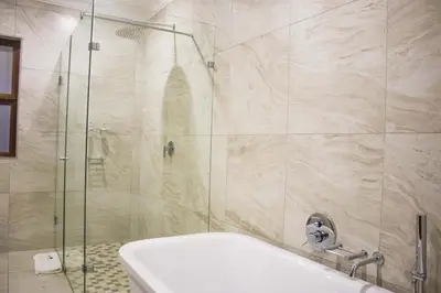 a bathroom with a shower with a tub and a sink at Keleo Safari Lodge in Bela-Bela