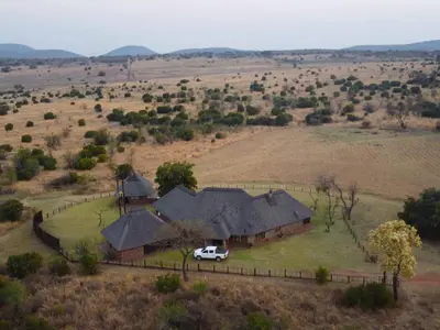 a car parked in front of a house in a field at Keleo Safari Lodge in Bela-Bela