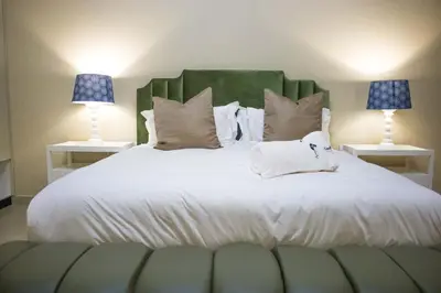 a bedroom with a large white bed with two lamps at Keleo Safari Lodge in Bela-Bela