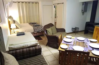 a living room with a couch and a table and chairs at Luilekker Chalets in Waterval-Onder