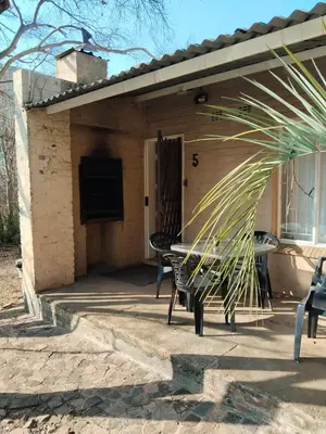a patio with a table and chairs on it at Luilekker Chalets in Waterval-Onder