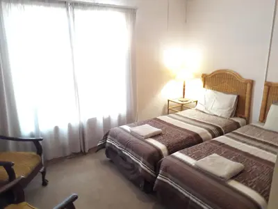 a hotel room with two beds and a lamp at Luilekker Chalets in Waterval-Onder
