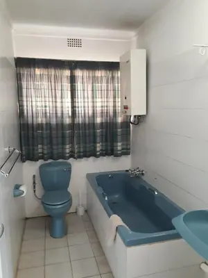 a bathroom with a blue toilet and a bath tub at Luilekker Chalets in Waterval-Onder
