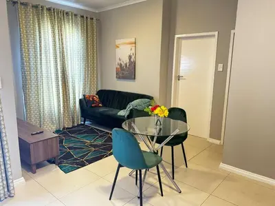 a living room with a glass table and a couch at The Pebbles in Midrand