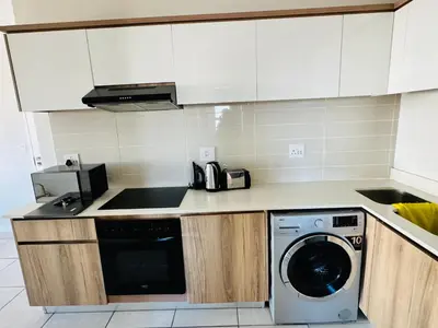 a kitchen with a washer and a washing machine at The Blyde Luxury Apartment in Pretoria