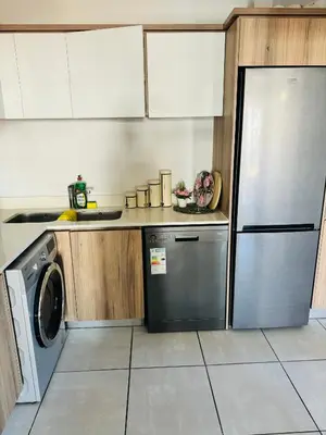 a kitchen with a refrigerator and a dishwasher at The Blyde Luxury Apartment in Pretoria